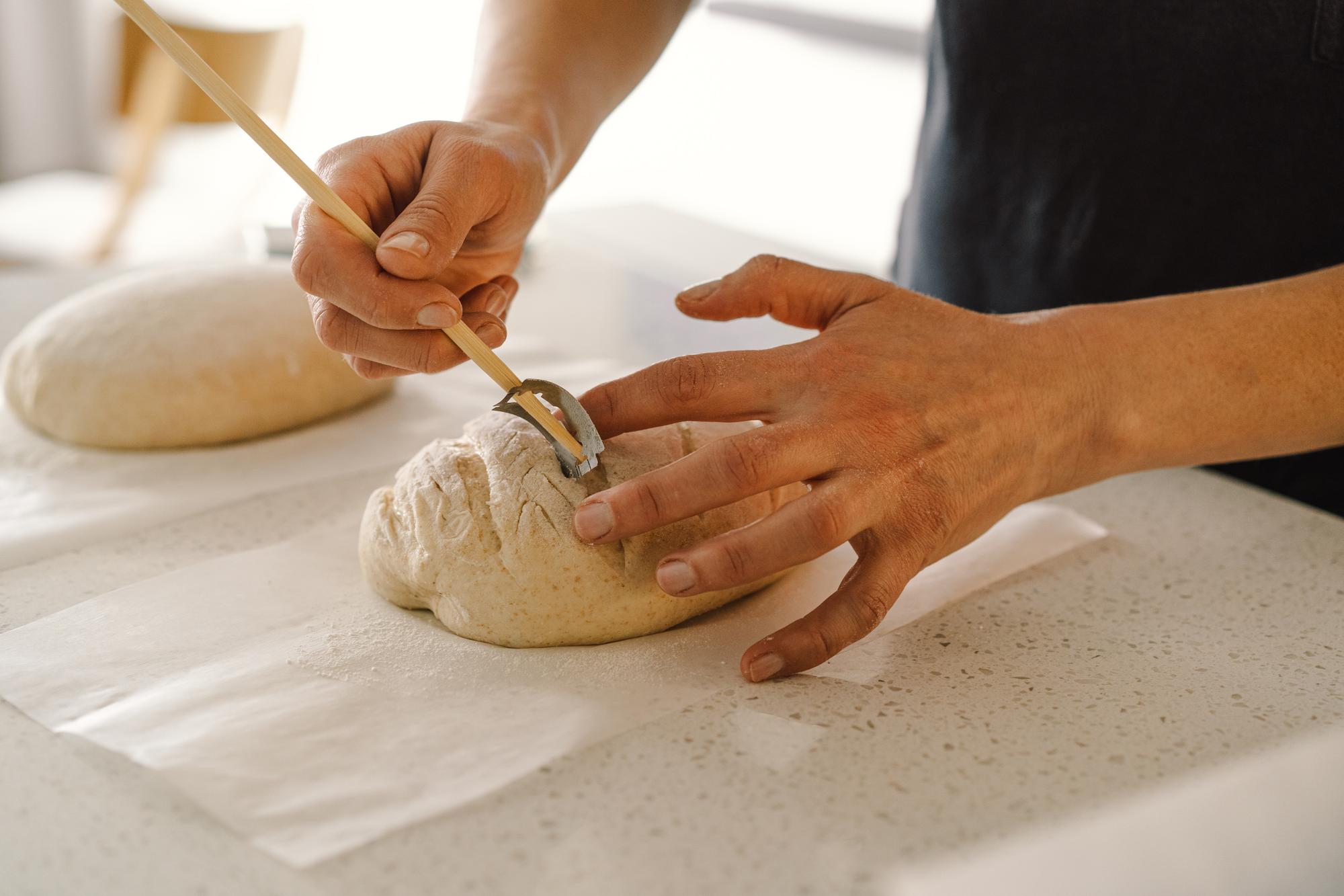 Dettaglio di mani che impastano pane artigianale